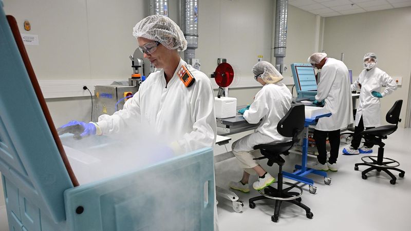 Equipe de quatre opérateurs en blouses et charlottes, au sein du Cryo Park du site de Sanofi Montpellier, au travail sur une chaîne de conditionnement.