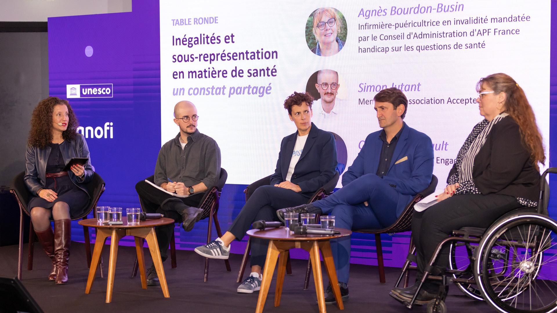 Les quatre intervenants de la table ronde consacrée aux inégalités en matière de santé sont assis côte-à-côte avec l’animatrice de la table ronde sur le côté de la scène.