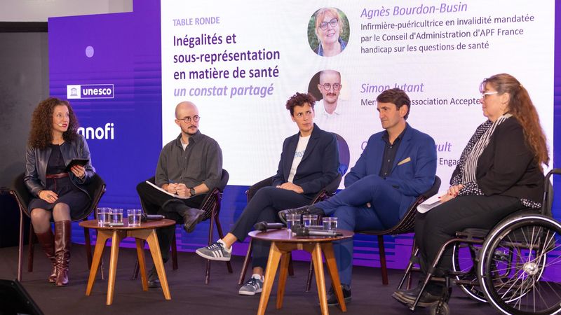 Les quatre intervenants de la table ronde consacrée aux inégalités en matière de santé sont assis côte-à-côte avec l’animatrice de la table ronde sur le côté de la scène.